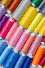 Top view of many colorful thread spools background