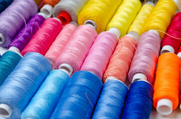 Top view of many colorful thread spools background