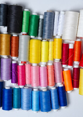 Top view of many colorful thread spools background