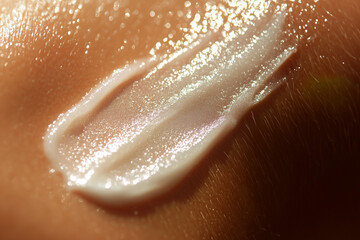 Fototapeta premium Gentle sunscreen lotion cream swatch close up detail on sun kissed woman skin summer concept.
