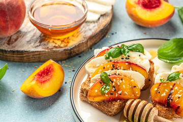 bread sandwiches with sweet peach slices, cream cheese and basil leaves. copy space for text. top view