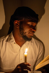 Man reading by candlelight, reflecting on deep thoughts and embracing peace