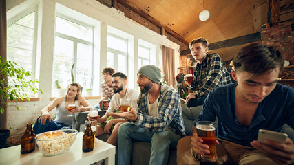 Tension high as everyone focuses on screen, holds beer in hand. Competition is fierce, but fun even...