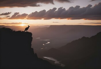 A kangaroo silhouette in a vibrant sunset landscape with mountains, clouds, and a flying bird