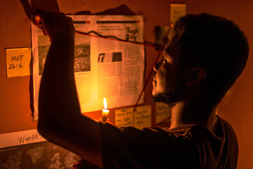 A scene of investigation into the signs and prophecies concerning the coming of Christ, illuminated by candlelight in a darkened room.