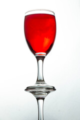 bottom view photo of reflective red liquid glass on white background.