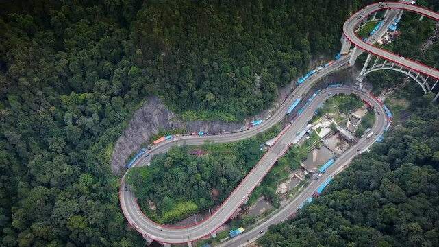 Kelok 9 or Kelok Sembilan is a winding road segment,9 sharp turns from drone, among the high hills with green and dense trees