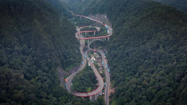 Kelok 9 or Kelok Sembilan is a winding road segment,9 sharp turns from drone, among the high hills with green and dense trees