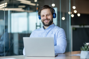 Smiling Man with Headphones in Modern Office Setting