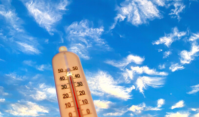 Thermometer for measuring outdoor air temperature. Meteorological device for observing and measuring the weather. Weather forecast. Thermometer on blue sky background. Hot weather, drought in summer.