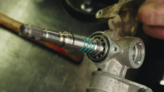 The technician installs the silicone o-ring in steering rack inner part covering bearing