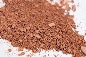 Scattered brown eyeshadow on a white background. Eye shadow texture