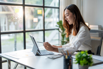 Young businesswoman working with tablet computer in modern office