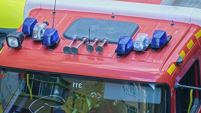 Close-up of a blue flashing light of a siren on a red car of firefighters, ambulance or rescuers.