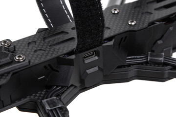 Modern FPV drone on a white back. Four-engine aircraft on the radio control. Drone for racing, filming and entertainment.