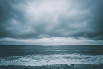 Fototapeta premium Overcast sky with thick, grey clouds covering the entire horizon, creating a moody and calm atmosphere