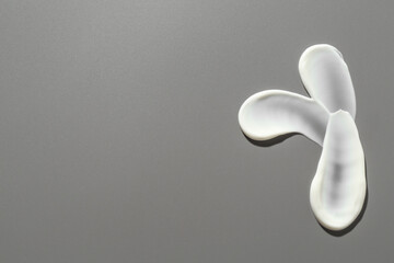 Smears of cosmetic products on grey background, top view. Space for text
