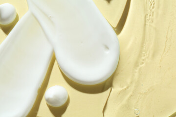 Smears of different cosmetic products on beige background, closeup