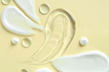 Smears of different cosmetic products on beige background, flat lay