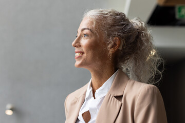 Feeling confident, smiling businesswoman in professional attire looking away