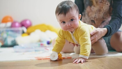 baby 6 months playing with a toy. kid in kindergarten playing on the floor many toys indoors. happy family baby dream concept. little infant baby play in kindergarten. happy childhood lifestyle