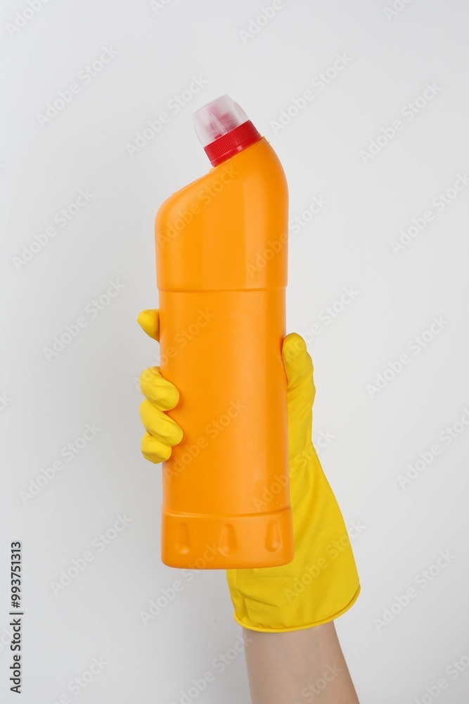 Canvas Prints Woman holding toilet cleaner in bottle on light background, closeup