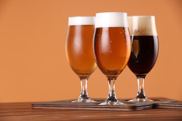 Glasses with different types of beer on wooden table