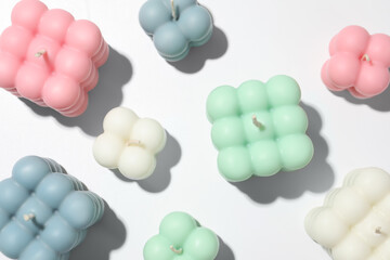 Beautiful bubble candles on white table, flat lay