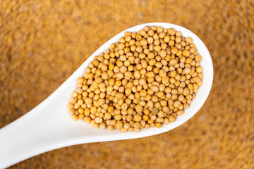 Mustard seeds in a spoon, natural organic seasoning