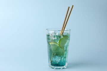 Tasty refreshing drink with straws in glass on light blue background