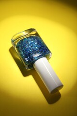 Nail polish in bottle on yellow background