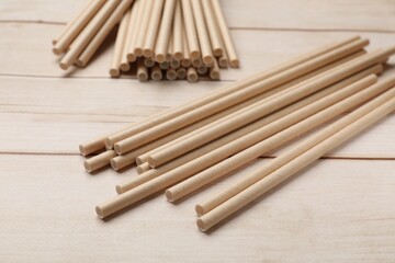 Bamboo drinking straws on wooden table, closeup