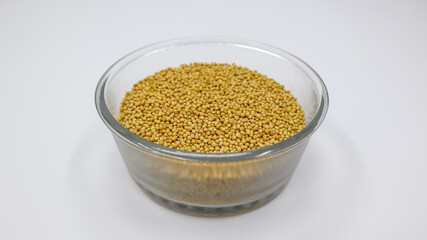 Yellow mustard seed grains in transparent bowl