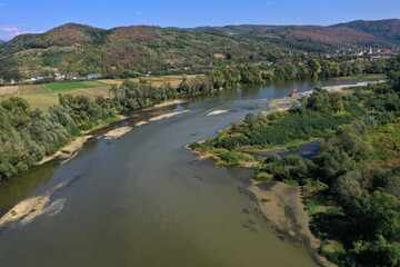 Flying over a river flowing on a plain aerial view