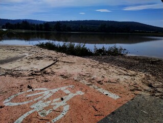 Bicycle path straight to water. Flood in Czech Republic. Road under water. Large amount of water on field. Disaster in Czech. Climate change. Clear blue sky after heavy rain. Weather in autumn.
