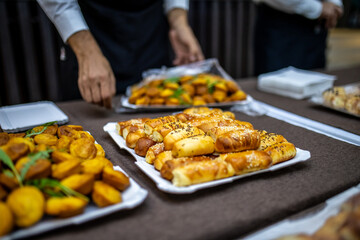 Assorted baked goods and snacks displayed on a table during an event at a banquet hall in the afternoon