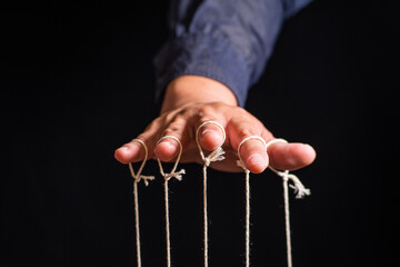 Close-up Of Man Controls The Puppet With Fingers. Man`s Hand Controls The Puppet With The Fingers...