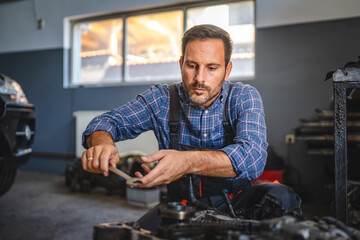 Car mechanic inspect car engine with tool at garage