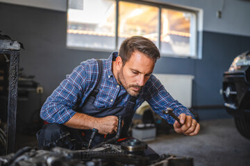 Car mechanic inspect car engine with tool at garage