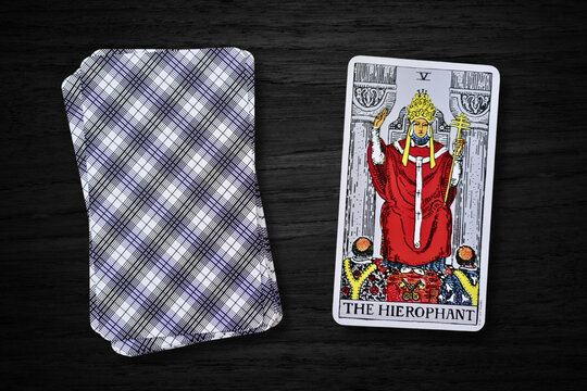 Carte de tarot "Le Pape" (The Hierophant) du jeu Rider-Waite, symbolisant la tradition, la spiritualit&eacute; et l'autorit&eacute; religieuse. Carte sur fond en bois sombre