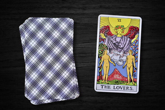 Carte de tarot "Les Amoureux" (The Lovers) du jeu Rider-Waite, repr&eacute;sentant l'amour, l'harmonie et les choix spirituels. Carte sur fond sombre en bois