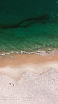 Aerial view of the beautiful turquoise sea with algae in Comporta, Portugal