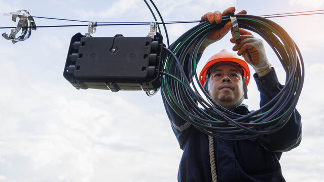 Engineer or technician checking fiber optic cables in internet splitter box.Fiber to the home equipment. FTTH internet fiber optics cables and cabinet...
