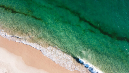 Aerial view of the beautiful turquoise sea with algae in Comporta, Portugal