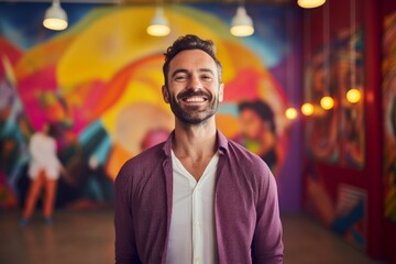 Fototapeta premium Portrait of a cheerful man in his 30s wearing a chic cardigan isolated on vibrant yoga studio background