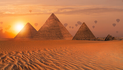 Hot air balloon flying over Giza Pyramid Complex at amazing sunset - Cairo, Egypt