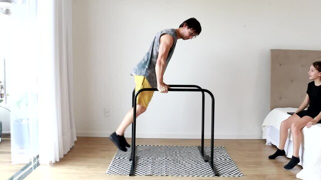 homem pratica exercicios em barra em casa 