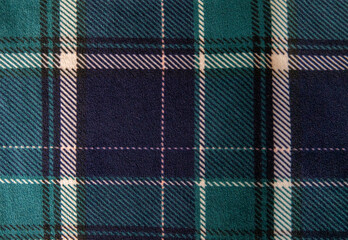 Green and blue tartan checkered textile fabric for background. Top view.