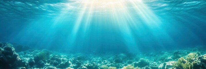 Blue ocean surface with coral reefs and sun rays coming from above