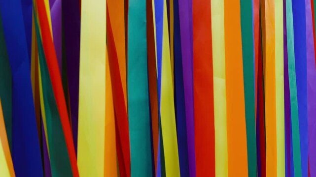 Colorful background. Many multicolored ribbons flutter on the wind.